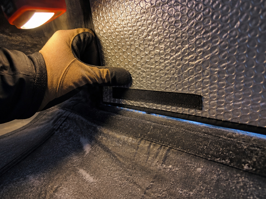 Close-up of insulating a tent wall with reflective bubble insulation in winter.