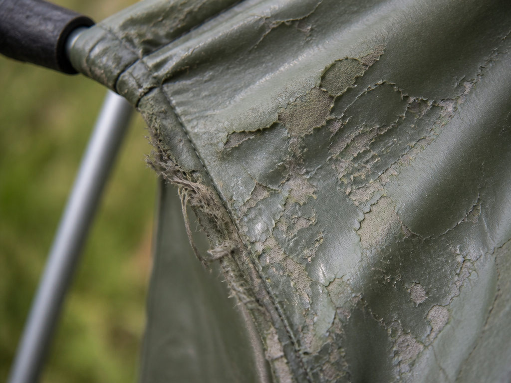 Close-up of badly damaged tent fabric with sticky, flaking coating